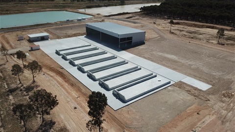 Wangaratta Organics Plant shed and cement pad surrounded by cleared land and dams in background 